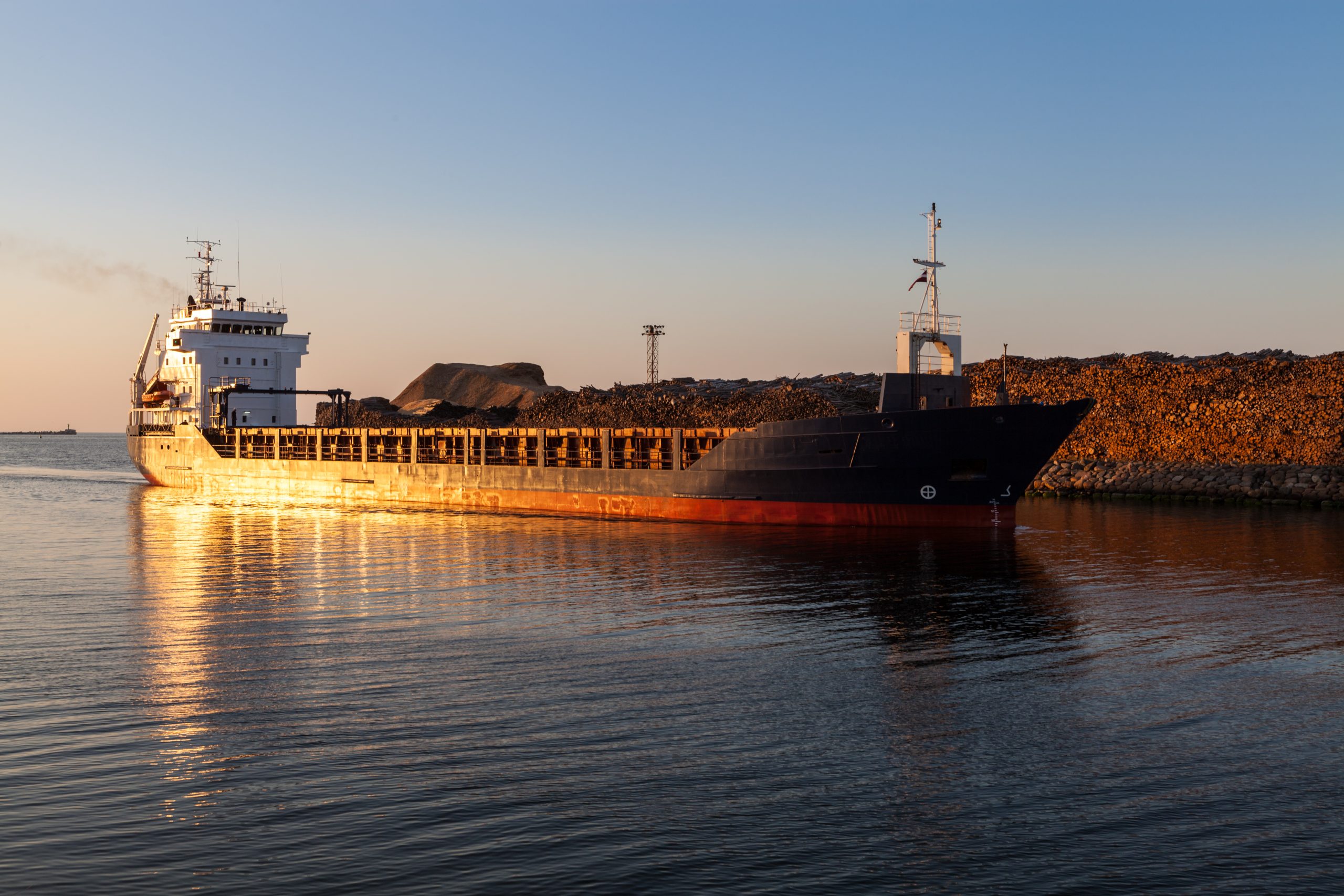 Freight ship in channel at sunset